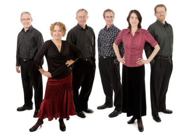 Group photo of musical group in studio on white background