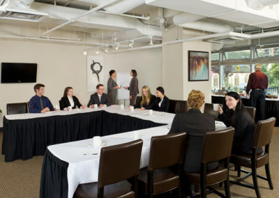 Professionals at a group meeting discuss business in posed in location photo