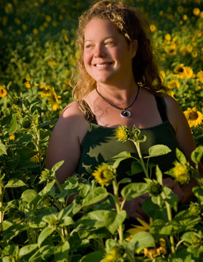 Portrait of a woman standing in a field of sunflowers