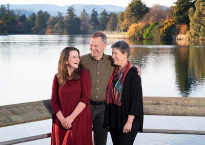 Family stands at waters edge for professional on location portraits